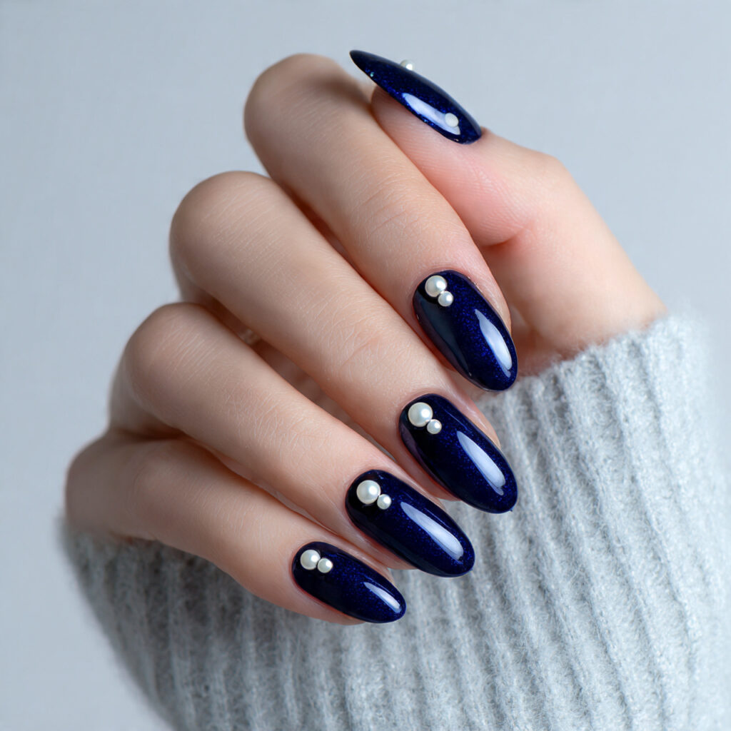midnight blue nails adorned with pearl accents