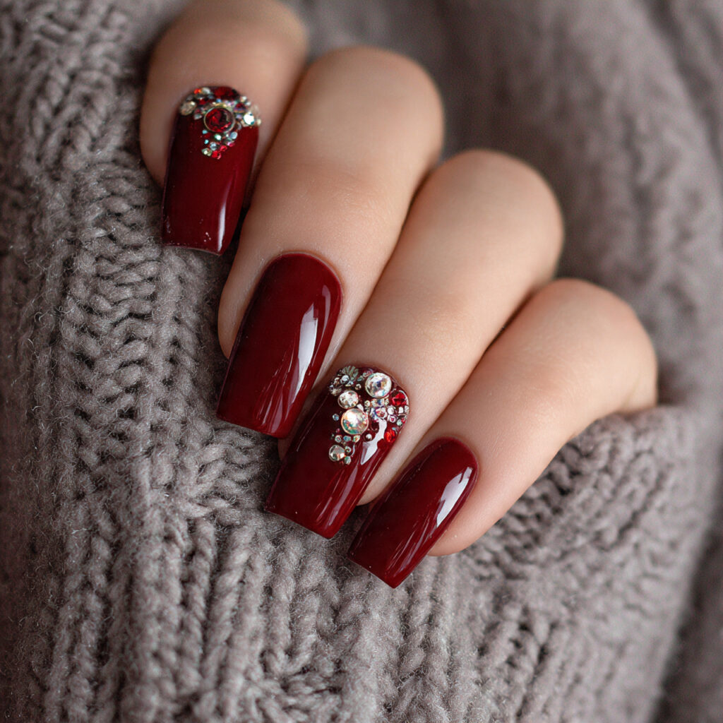 nails with deep red polish and rhinestones