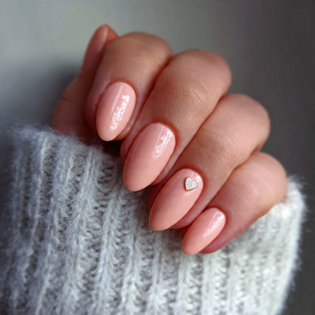 soft peach nails with tiny heart accent