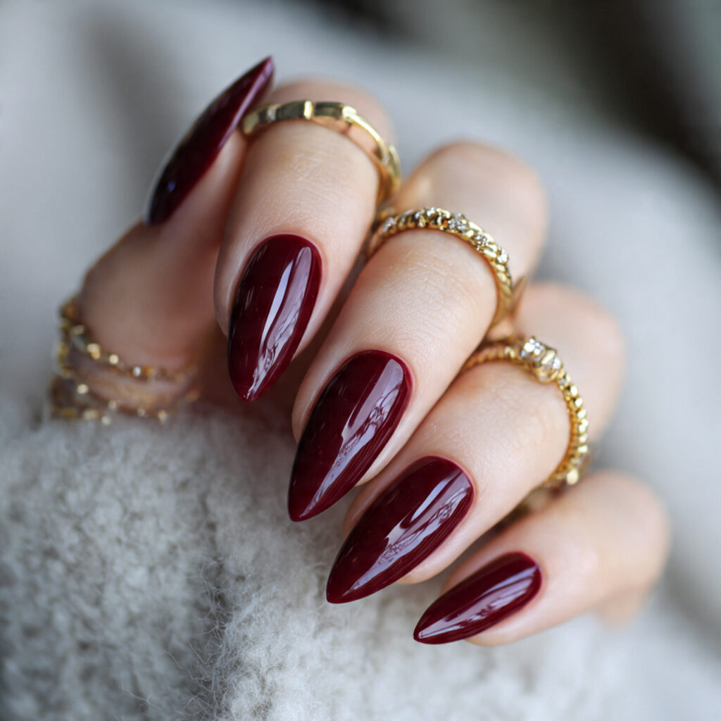 glossy deep red almond shaped nails in rich